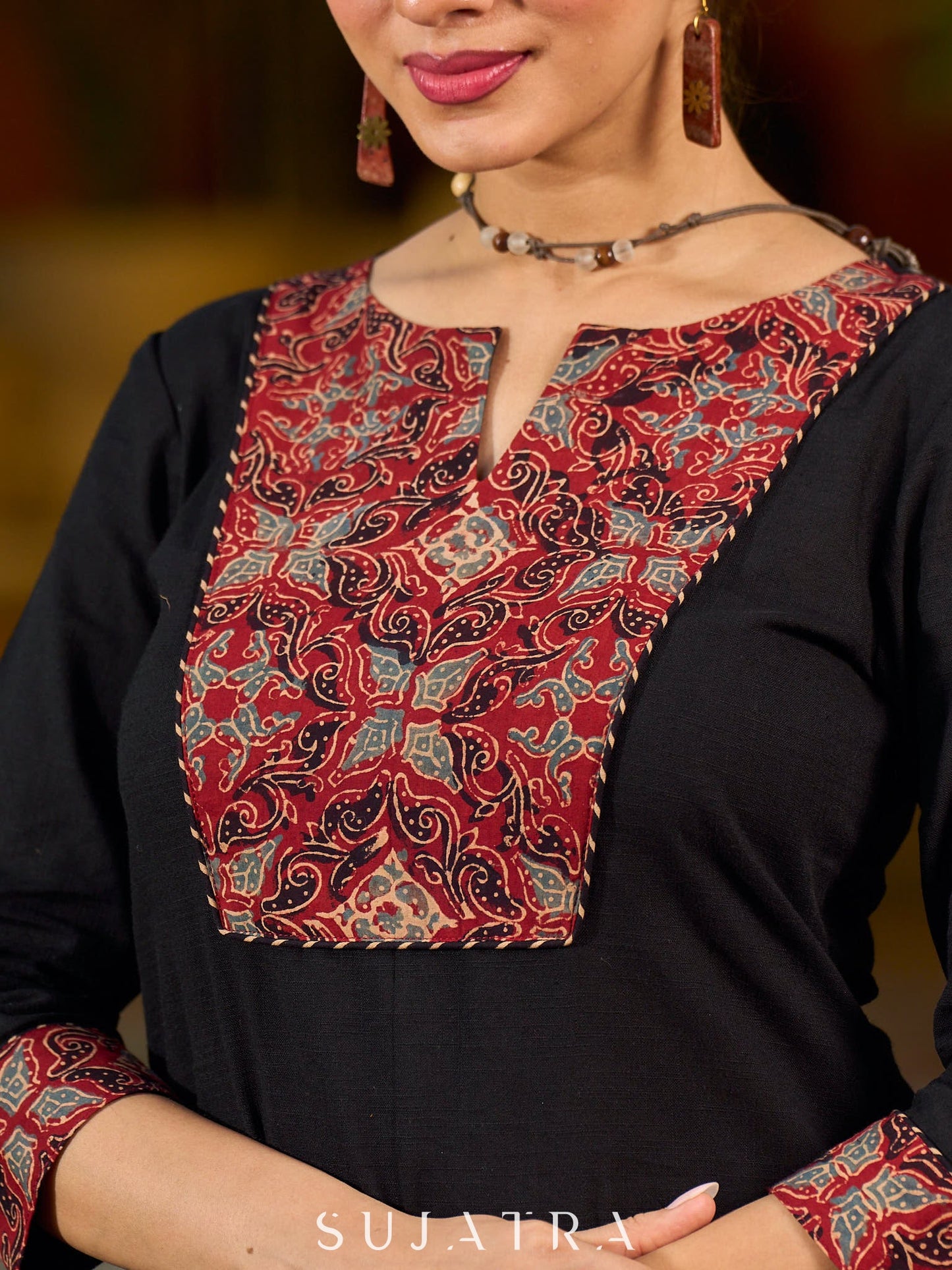 elegant black cotton kurta with beautifully crafted ajrakh panel and subtle stripe piping accents
