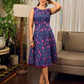 Enchanting purple panel dress featuring vibrant magenta floral prints, a sleeveless silhouette, and a graceful fit-and-flare design for timeless elegance.