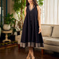 Modern black bias-cut dress showcasing unique artisan-inspired Kalamkari neck trim.