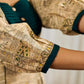 Artisanal beige Madhubani dress featuring intricate motifs, a contrasting green yoke, and refined accents.