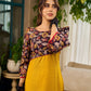 Mustard Kalamkari dress with an asymmetrical yoke and puffed sleeves.