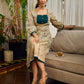 Artisanal beige Madhubani dress featuring intricate motifs, a contrasting green yoke, and refined accents.