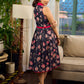 Elegant black Kalamkari dress featuring blooming florals and contrasting pink detailing for refined charm.