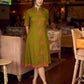 Gorgeous olive dress with pink abstract triangle hand block prints placed at the centre, sleeves, and back, featuring a mandarin collar and half sleeves for a refined, contemporary look.