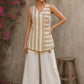 Charming white and mustard sleeveless wrap top featuring a distinctive Block print pattern, elegant mustard piping, and a graceful, contemporary, artisan-inspired tailored silhouette.