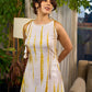 Sunlit ivory tie-dye dress with mustard accents and playful tassel shoulder detailing.