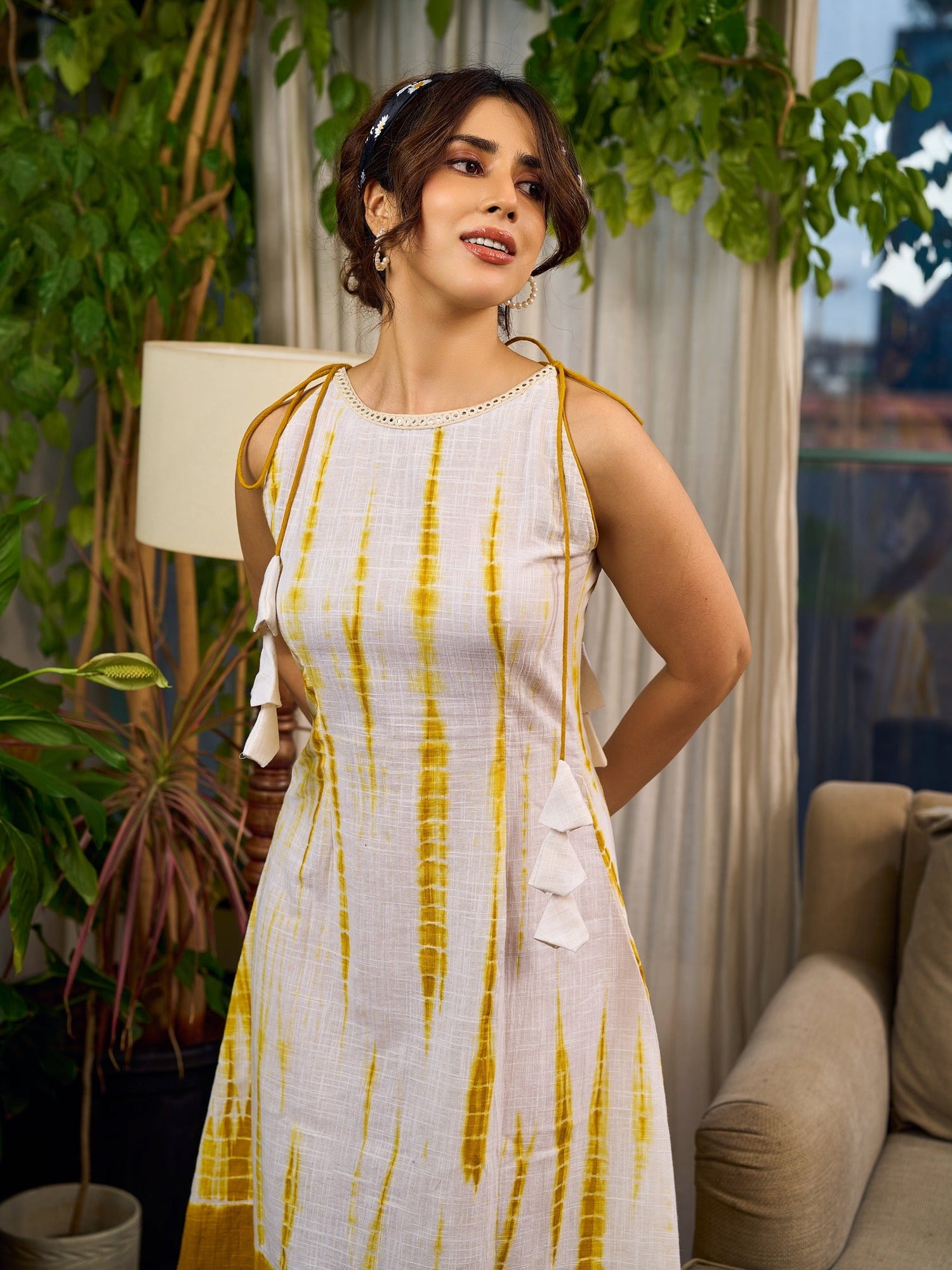 Sunlit ivory tie-dye dress with mustard accents and playful tassel shoulder detailing.