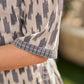 Modern white and grey Ikat shirt dress elevated with an asymmetrical checkered Ikat collar and contrast black accents.