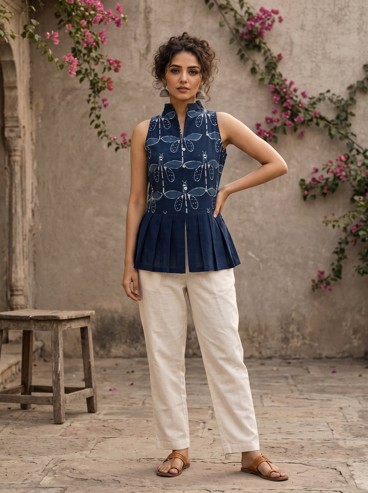 Contemporary indigo top with delicate dragonfly motifs, high folded collar, and graceful pleated hemline.