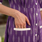 Purple Ikat dress with a notch collar, softly gathered sleeves, crisp white accents, a gently gathered upper waist, and functional slip-in pockets.