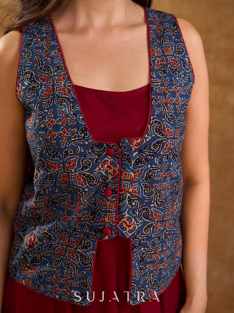 Handcrafted Ajrakh sleeveless jacket featuring front flaps, maroon detailing, breathable fabric, and a contemporary ethnic fusion appeal.