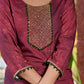 Exquisite deep burgundy printed kurta with intricate neck panel embroidery, delicate green beads, and refined green highlights.