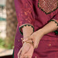 Exquisite deep burgundy printed kurta with intricate neck panel embroidery, delicate green beads, and refined green highlights.