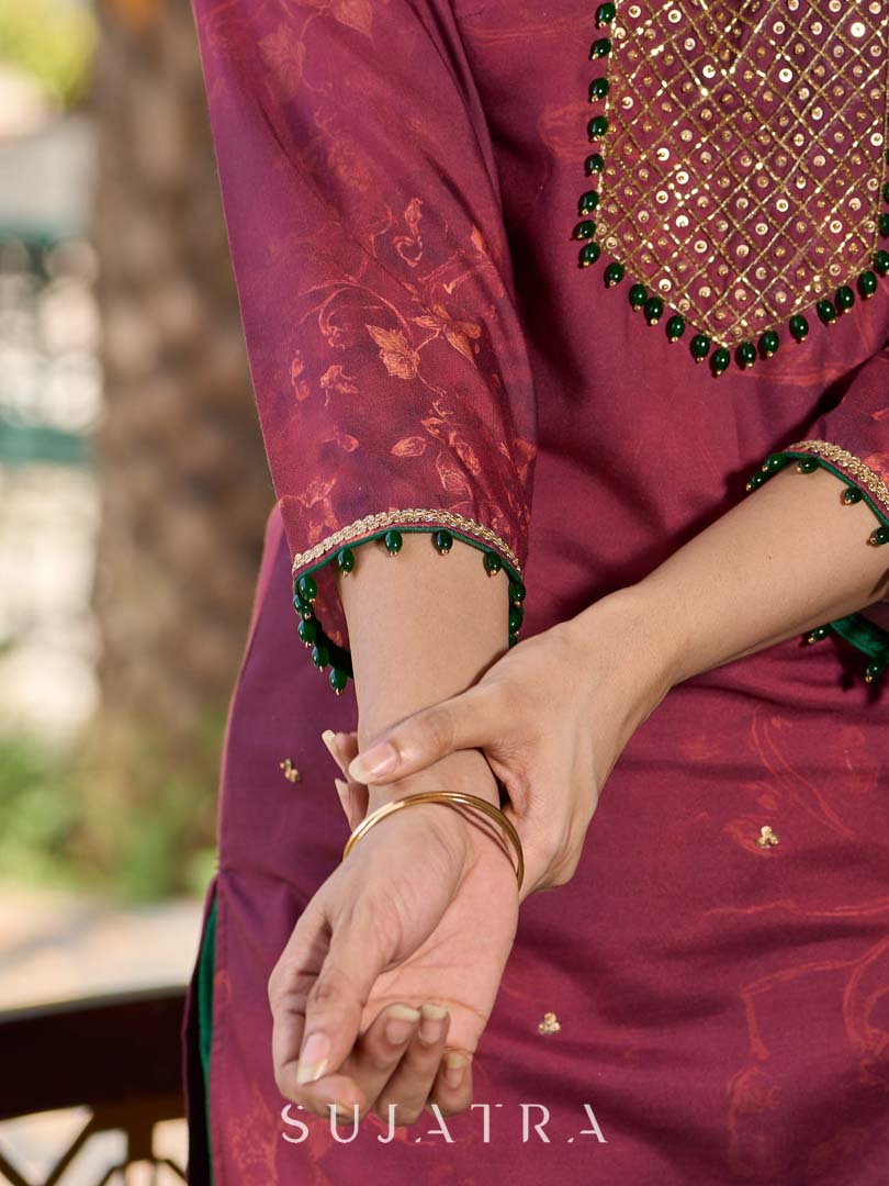 Exquisite deep burgundy printed kurta with intricate neck panel embroidery, delicate green beads, and refined green highlights.