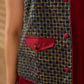 Sharp dark teal and maroon checkered sleeveless jacket with a distinctive notch collar and princess-cut tailoring, offering a structured silhouette ideal for elevated corporate styling.