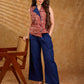 Sharp sleeveless red Kalamkari overlap jacket with a statement one-sided flap, Chinese collar, and navy accents, offering a clean, structured silhouette ideal for elevated corporate styling.