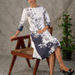White and black floral dress with pearl embellishments and black accents.