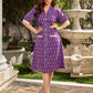 Purple Ikat dress with a notch collar, softly gathered sleeves, crisp white accents, a gently gathered upper waist, and functional slip-in pockets.