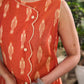 Statement orange Ikat side-wrap dress elevated with scalloped edges and subtle cream accents.