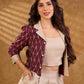 Smart maroon Ikat jacket featuring gathered sleeves, a cream notch collar, and subtle accents, creating a defined, structured silhouette suited for polished corporate wear.