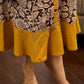 Heritage Kalamkari dress with elegant mustard accents and black pearl embellishments.