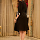 Chic black overlapping blazer-style wrap dress featuring printed black-and-white collar, cuffs, tie detail, and subtle accents
