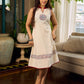 Off-white dress featuring intricate Madhubani artwork and a maroon Mandarin collar.