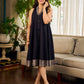 Modern black bias-cut dress showcasing unique artisan-inspired Kalamkari neck trim.