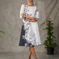 White and black floral dress with pearl embellishments and black accents.