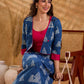 Deep indigo jacket with an asymmetric front closure, magenta folded cuffs, and coordinated accents, offering a structured silhouette with bold contrast and a refined look for elevated corporate styling.