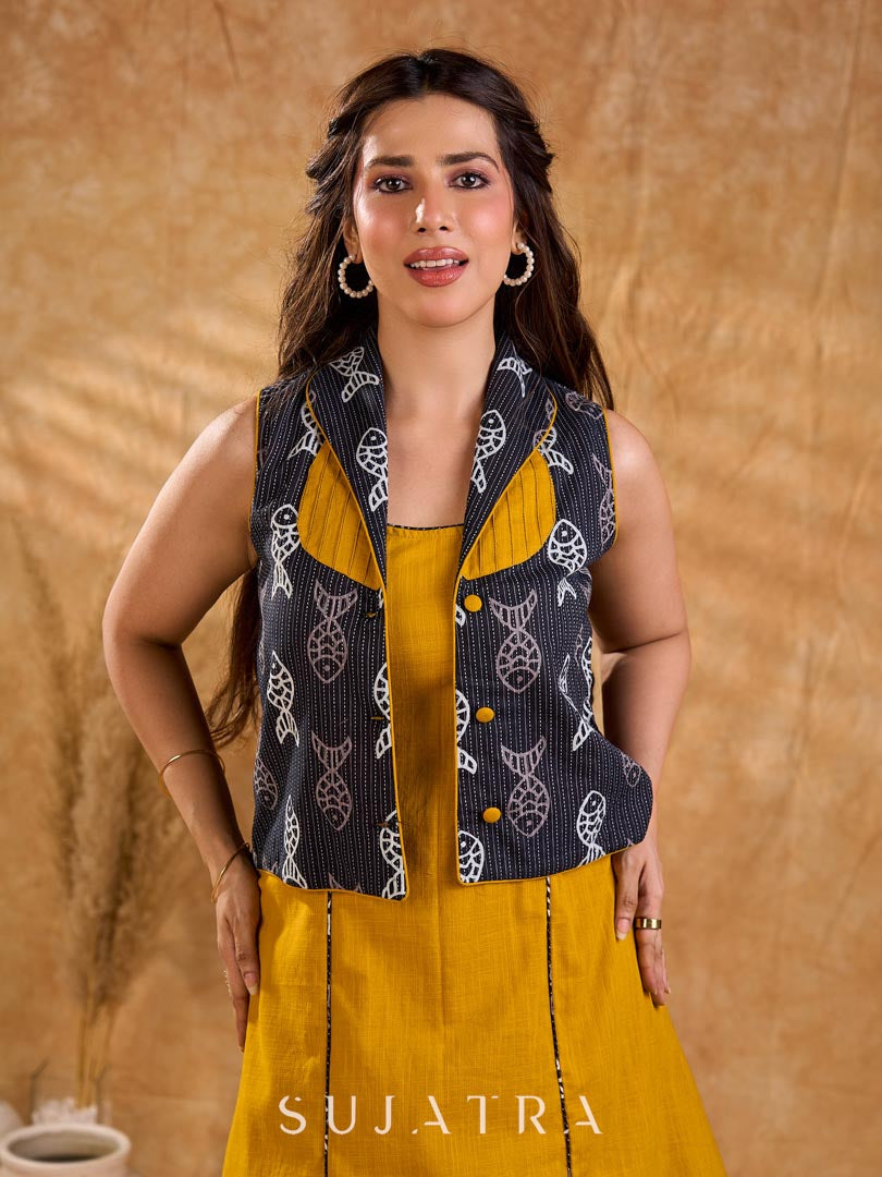 Tailored black Kantha jacket featuring fish motifs, a mustard pintuck patch, and a flipped collar, offering a structured silhouette with refined detail and distinctive, contemporary character.