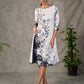 White and black floral dress with pearl embellishments and black accents.