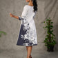 White and black floral dress with pearl embellishments and black accents.
