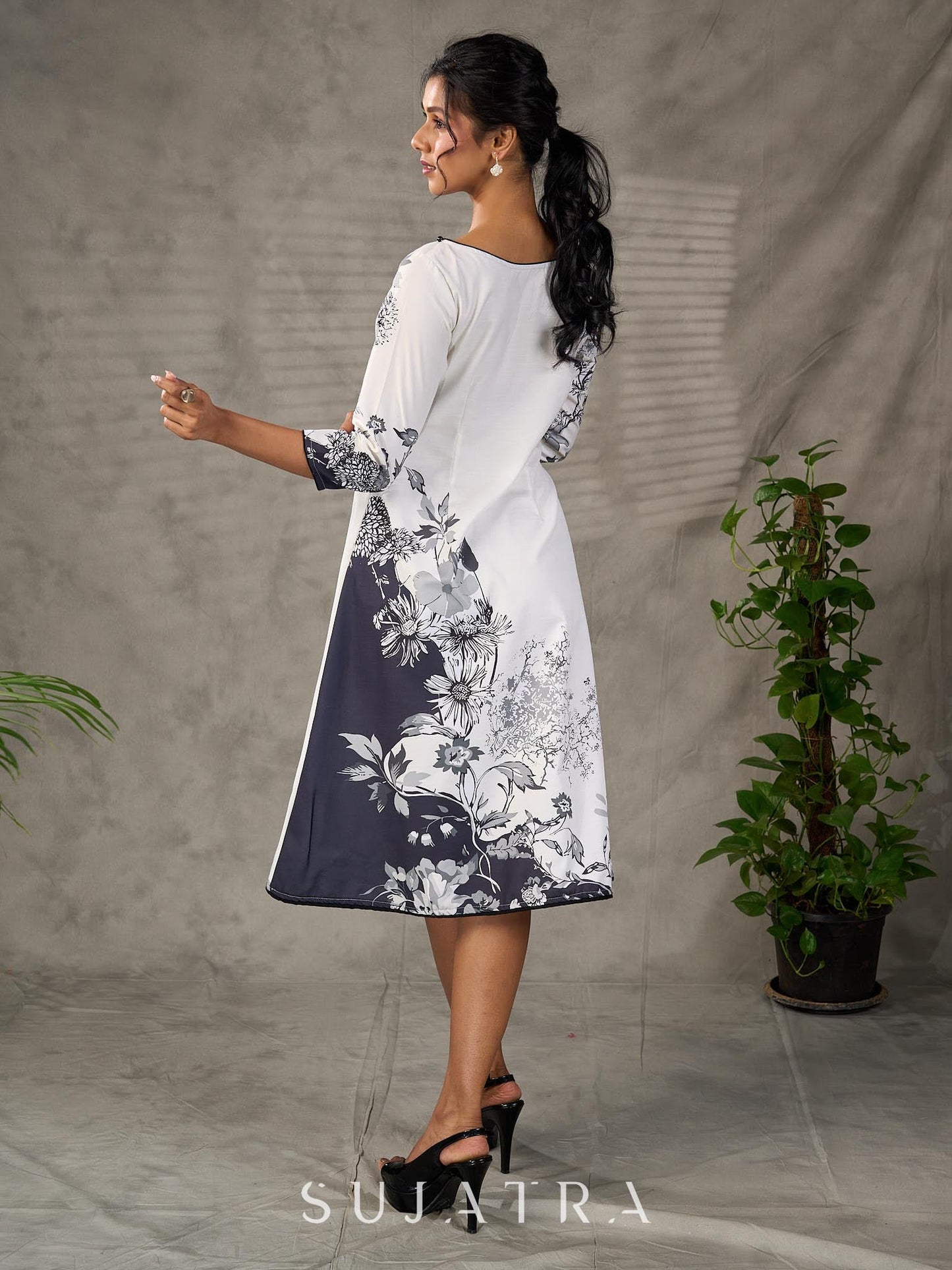 White and black floral dress with pearl embellishments and black accents.