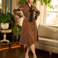 Brown block print dress with floral block printed flared sleeves, black tie-up neckline, and contrast black accents for an effortless, elegant everyday look.