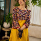 Mustard Kalamkari dress with an asymmetrical yoke and puffed sleeves.