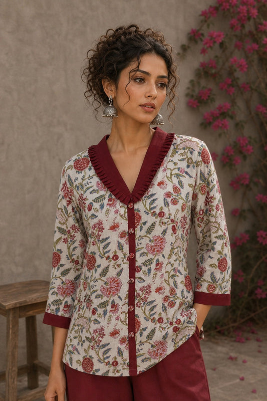 Soft white floral cotton top finished with maroon cuffs, pleated collar, and delicate feminine elegance.