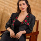 Exquisite black Ikat jacket with offset collar flaps and detailed red floral vine embroidery, delivering a sculpted, high-impact silhouette with refined presence for corporate styling.