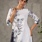 White and black floral dress with pearl embellishments and black accents.