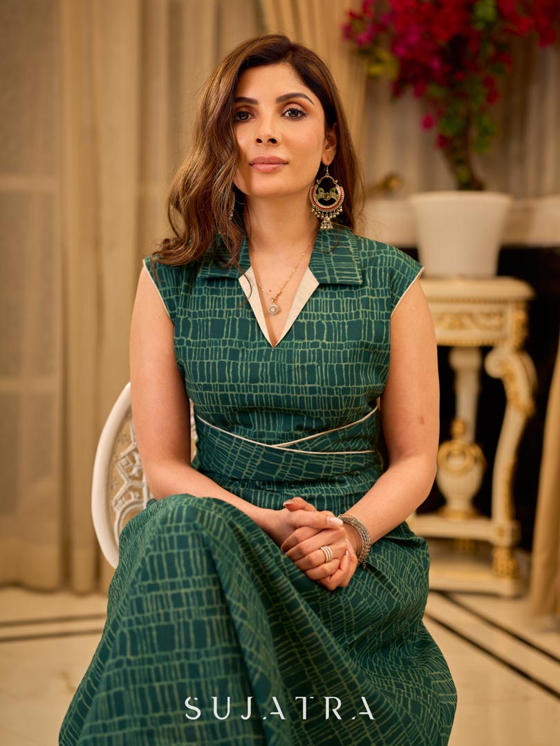 Teal Printed Sleeveless Crossover Midi Designed in a rich teal print, highlighting a crisp notched collar, defined wrap waist, and a fluid flared silhouette.