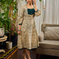 Artisanal beige Madhubani dress featuring intricate motifs, a contrasting green yoke, and refined accents.