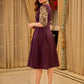 Playful purple cotton dress showcasing floral puff sleeves and box pleats released from the dart for soft volume and flow