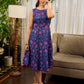 Enchanting purple panel dress featuring vibrant magenta floral prints, a sleeveless silhouette, and a graceful fit-and-flare design for timeless elegance.