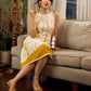 Sunlit ivory tie-dye dress with mustard accents and playful tassel shoulder detailing.