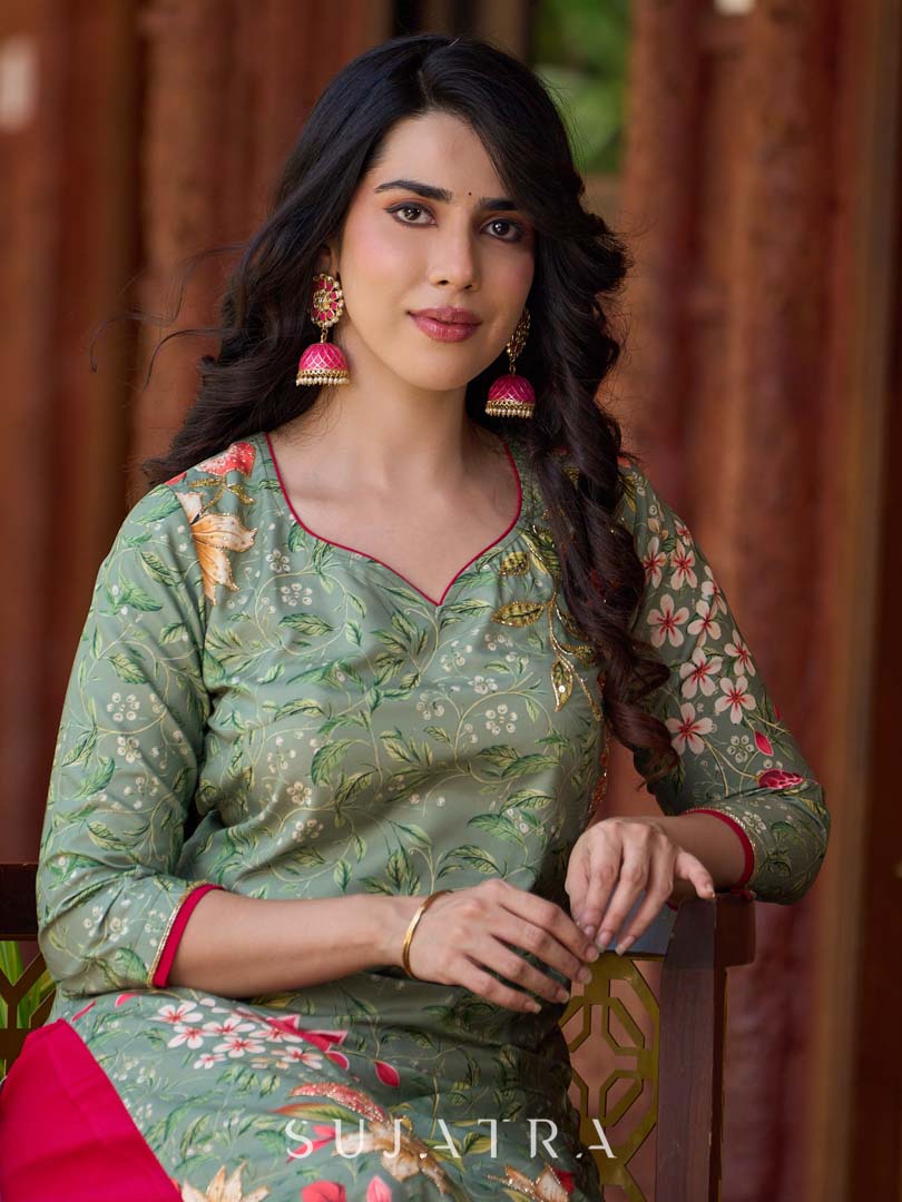 Soft green printed kurta with vibrant floral motifs, highlighted with hand embroidery and bright magenta accents.