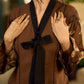 Brown block print dress with floral block printed flared sleeves, black tie-up neckline, and contrast black accents for an effortless, elegant everyday look.