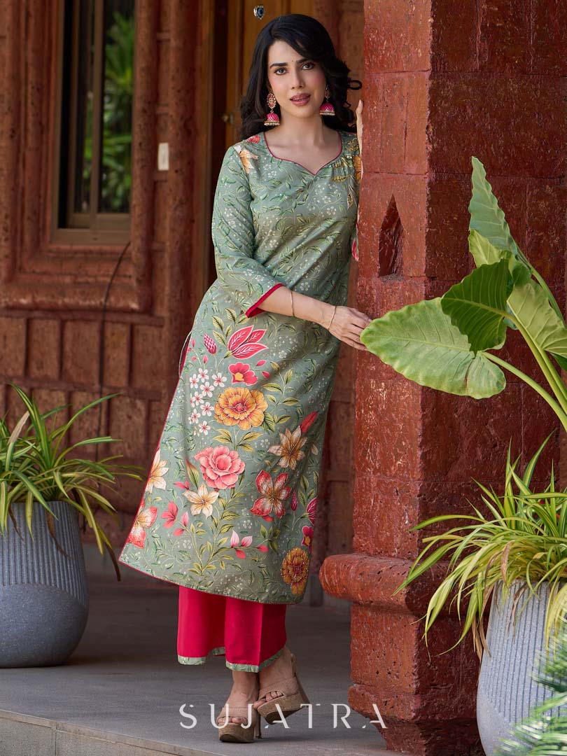 Soft green printed kurta with vibrant floral motifs, highlighted with hand embroidery and bright magenta accents.