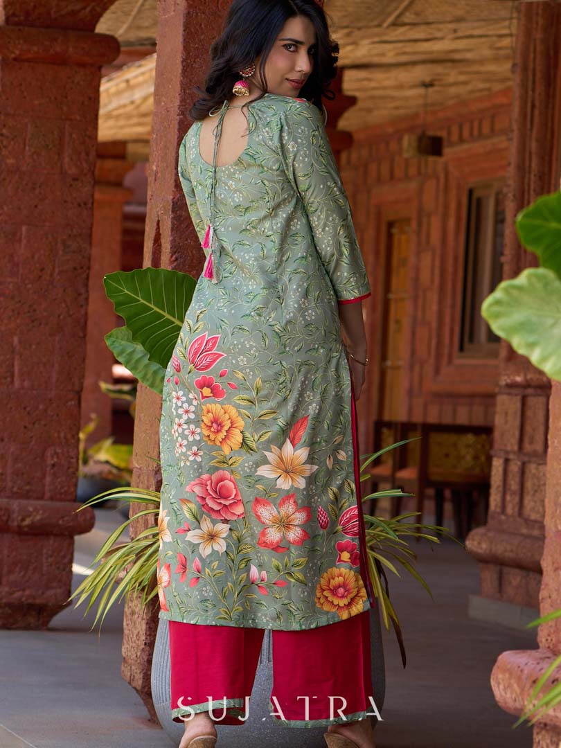 Soft green printed kurta with vibrant floral motifs, highlighted with hand embroidery and bright magenta accents.
