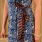 Chic indigo wrap-style dress featuring animal-inspired motifs with a striped belt and refined accents.
