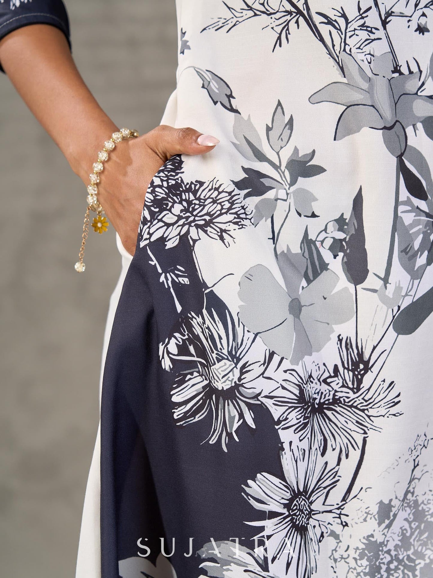 White and black floral dress with pearl embellishments and black accents.
